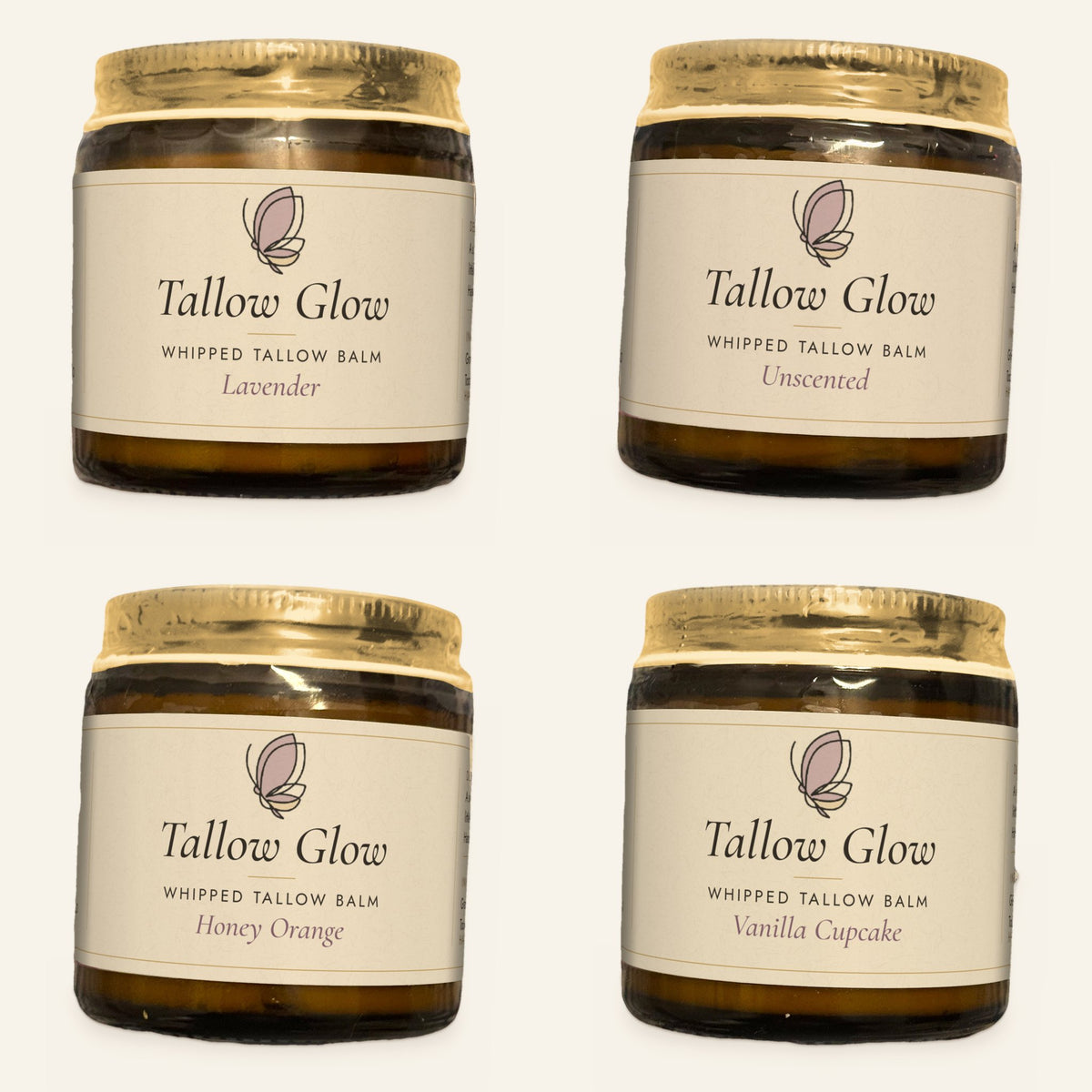Four jars of Tallow Glow whipped tallow balm in Lavender, Unscented, Honey Orange and Vanilla Cupcake, each with a gold lid and cream label, on a plain cream background