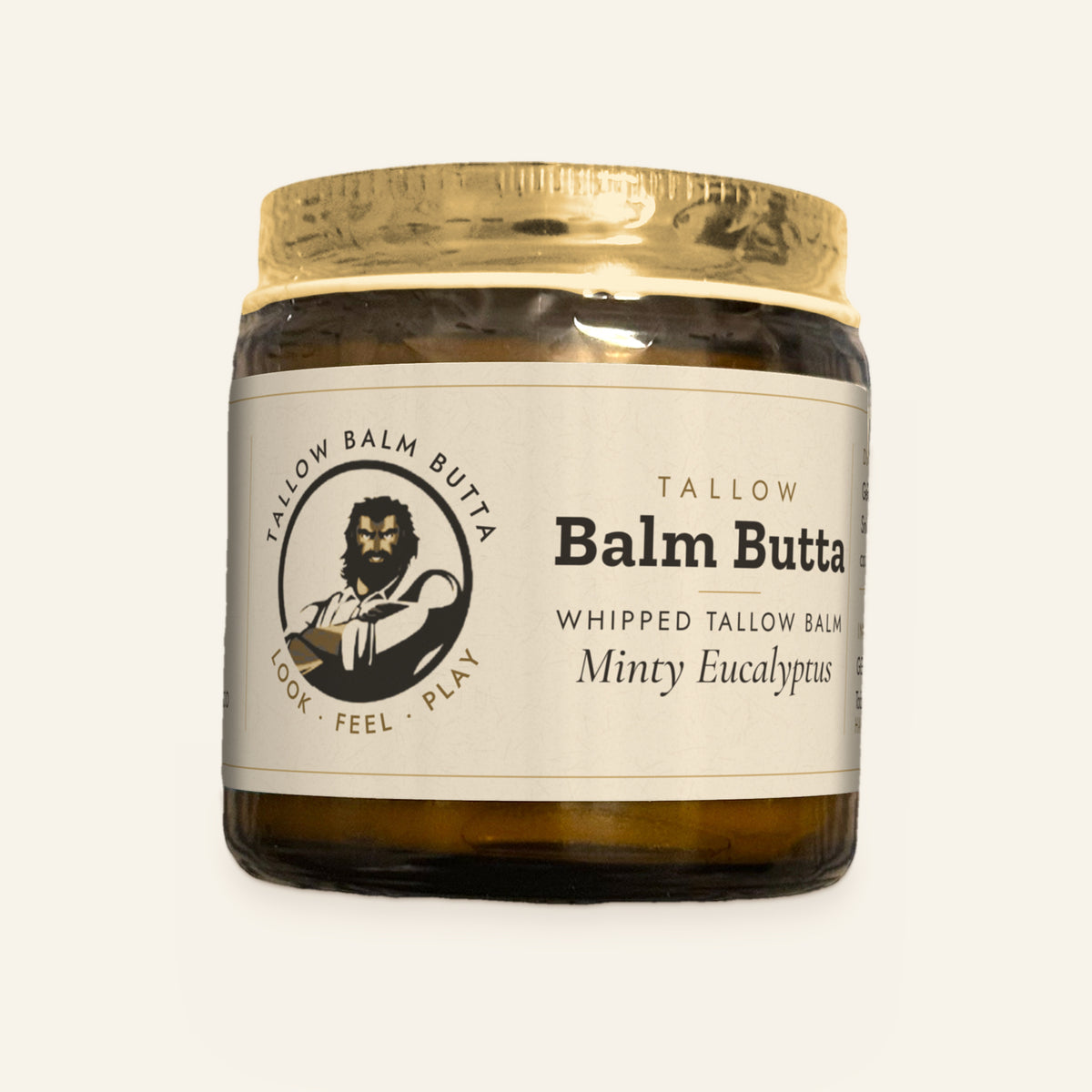 Tallow Roots Co. Minty Eucalyptus Balm Butta whipped tallow balm in a glass jar with gold lid and cream label, front view on a plain cream background