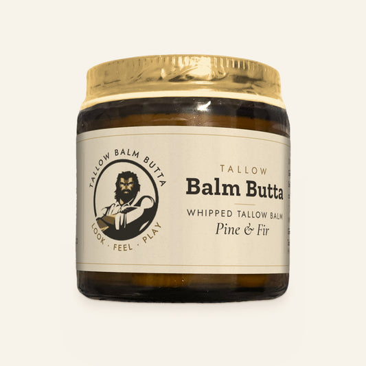 Tallow Roots Co. Pine & Fir Balm Butta whipped tallow balm in a glass jar with gold lid and cream label, front view on a plain cream background