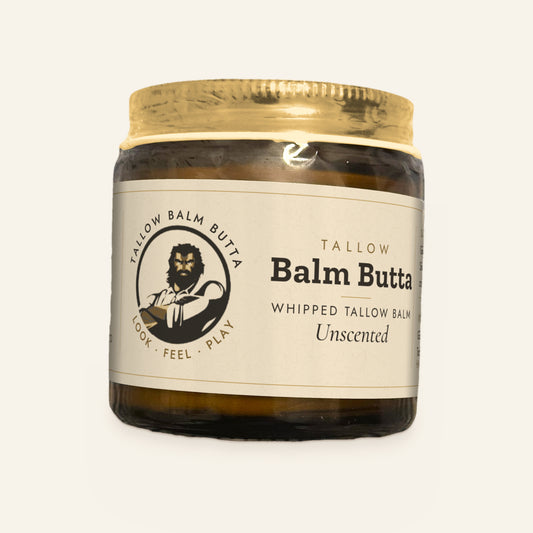 Tallow Roots Co. Unscented Balm Butta whipped tallow balm in a glass jar with gold lid and cream label, front view on a plain cream background