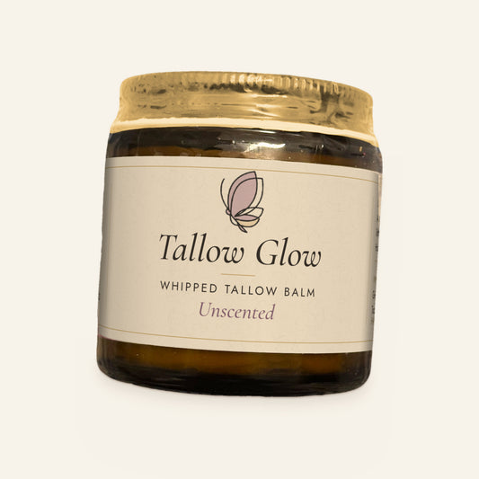 Tallow Roots Co. Unscented Tallow Glow whipped tallow balm in a glass jar with gold lid and cream label, front view on a plain cream background