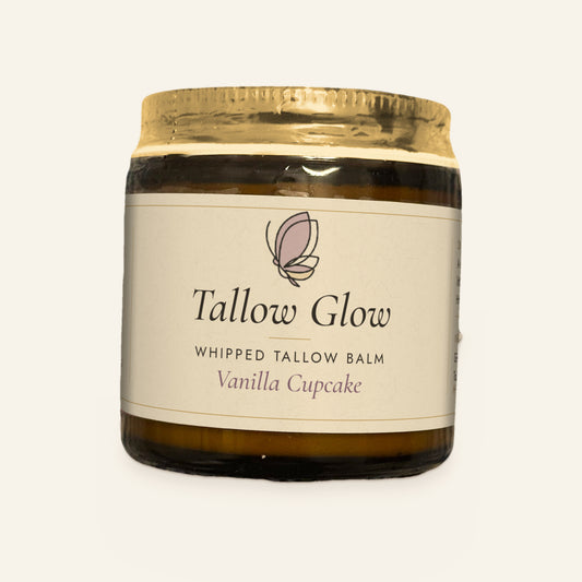 Tallow Roots Co. Vanilla Cupcake Tallow Glow whipped tallow balm in a glass jar with gold lid and cream label, front view on a plain cream background
