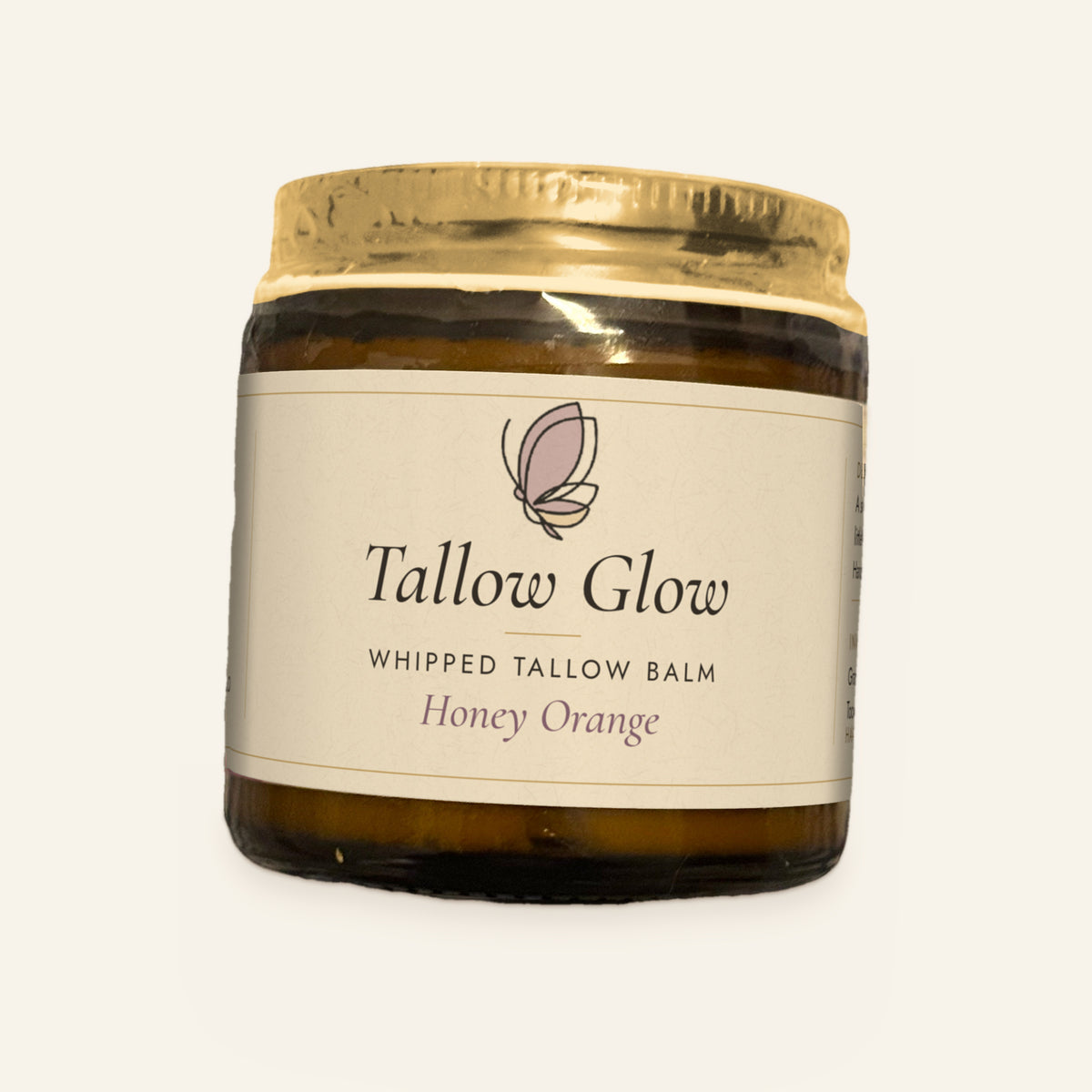 Tallow Roots Co. Honey Orange Tallow Glow whipped tallow balm in a glass jar with gold lid and cream label, front view on a plain cream background